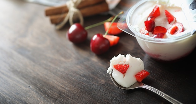 Yogurt fresco con frutti di bosco. Gelato in una ciotola con fragole e ciliegie fresche e succose. Dolce ai frutti rossi.