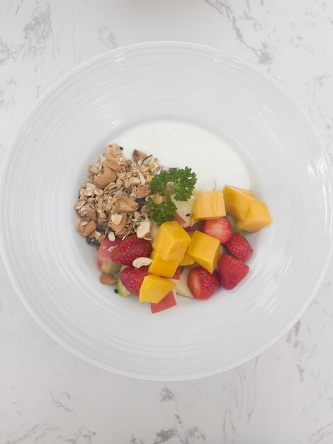 Yogurt greco con grano di frutta fresca e miele in una ciotola