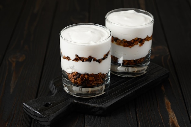 Yogurt greco con muesli su un fondo di legno scuro di legno