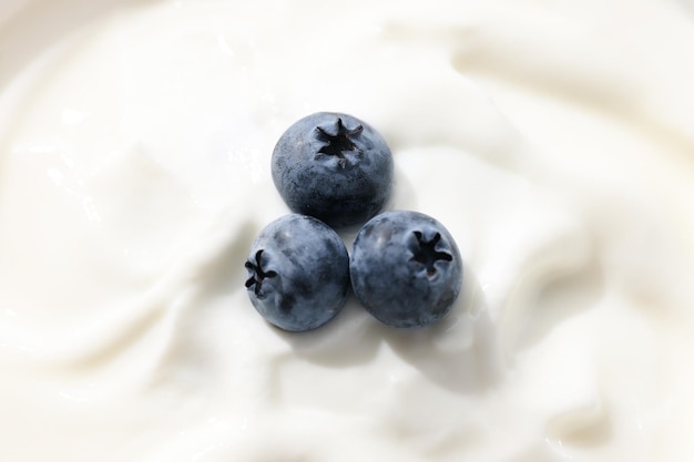 Yogurt greco e tre mirtilli da vicino