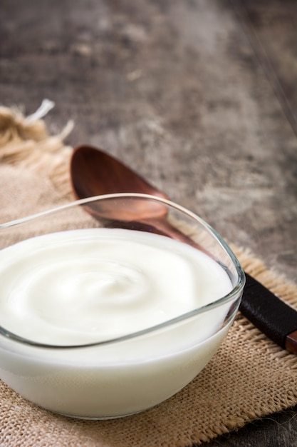 Yogurt greco in ciotola di vetro sulla tavola di legno