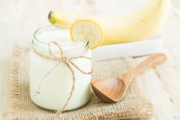 Yogurt in bottiglie di vetro sul tavolo di legno