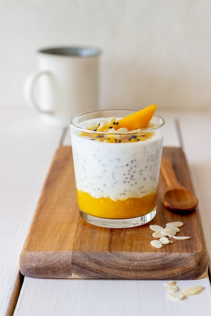 Yogurt in un bicchiere con mango, chia e mandorle. Mangiare sano. Cibo vegetariano. Ricetta. Colazione. Dieta.