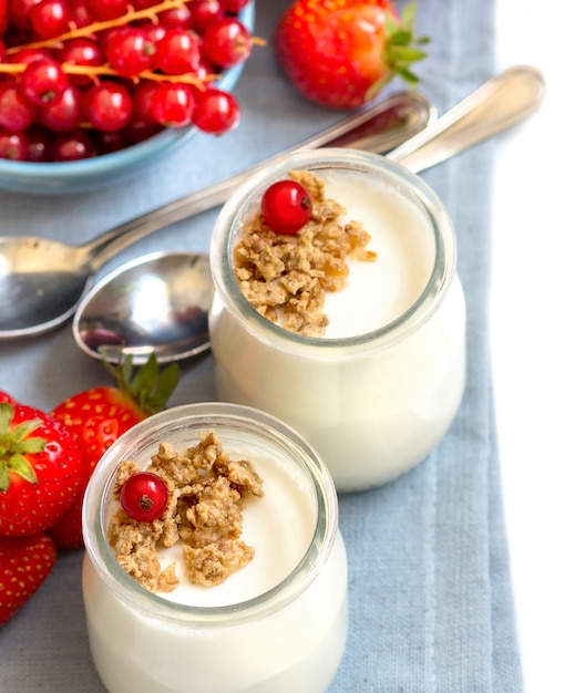 Yogurt naturale, bacche fresche e cereali su un tovagliolo. Concetto di colazione sana