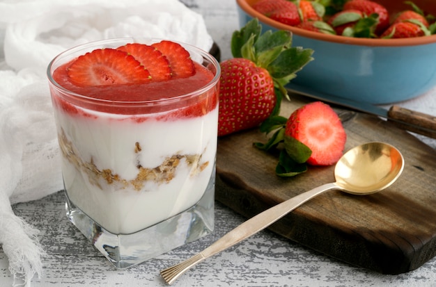 Yogurt naturale fatto in casa con fragole e muesli.