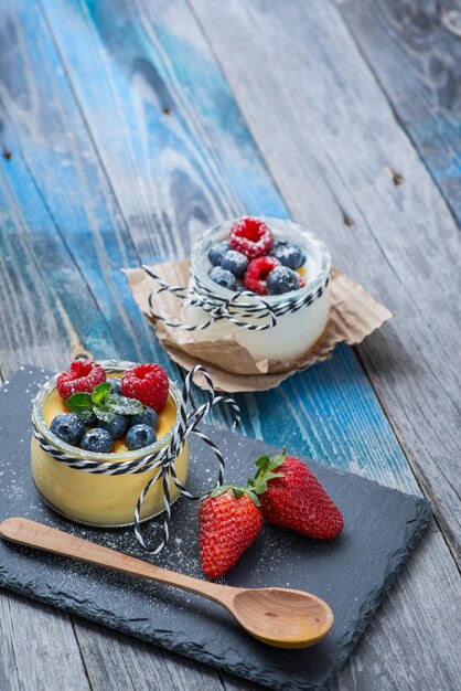 Yogurt naturale fresco e sano con frutti di bosco sulla tavola di legno