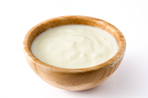 Yogurt naturale in ciotola di legno isolata