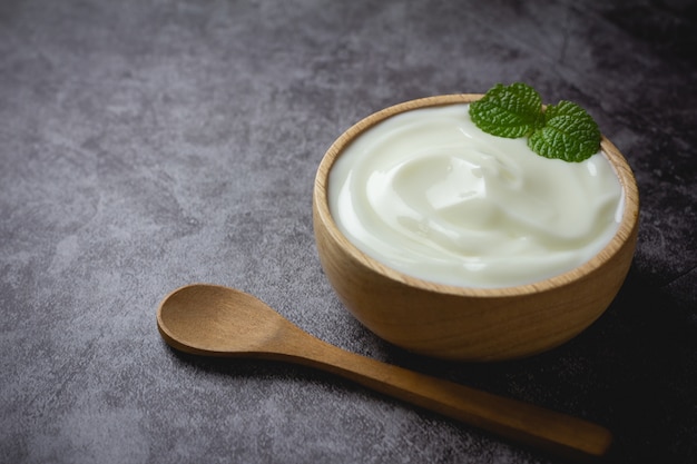 Yogurt normale in ciotola di legno sul tavolo