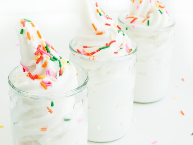 Yogurt soft-serve congelato in vetro su sfondo bianco.