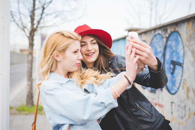 Youn bella ragazza bionda e bruna prendendo selfie