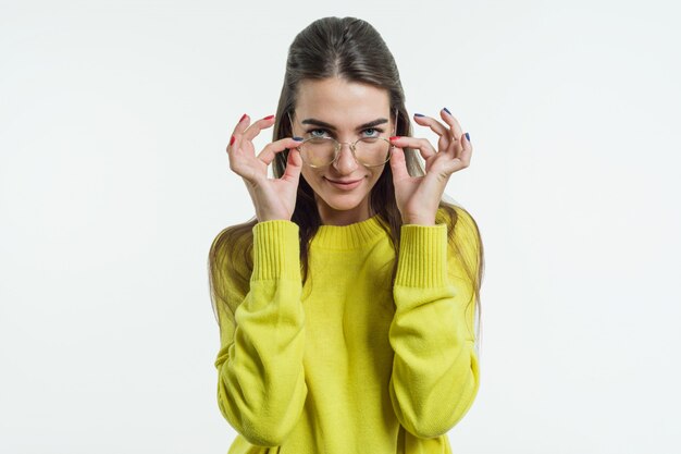 Young attractive girl in a bright yellow sweater