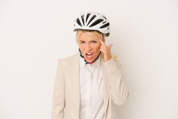 Young business donna russa che tiene il casco della bici isolato su sfondo bianco che mostra un gesto di delusione con l'indice.