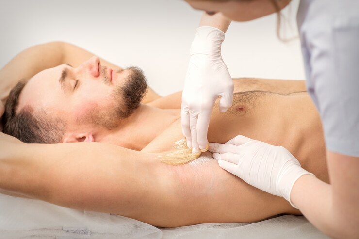 young caucasian man receiving hair removal from his armpit in a beauty salon depilation men underarm