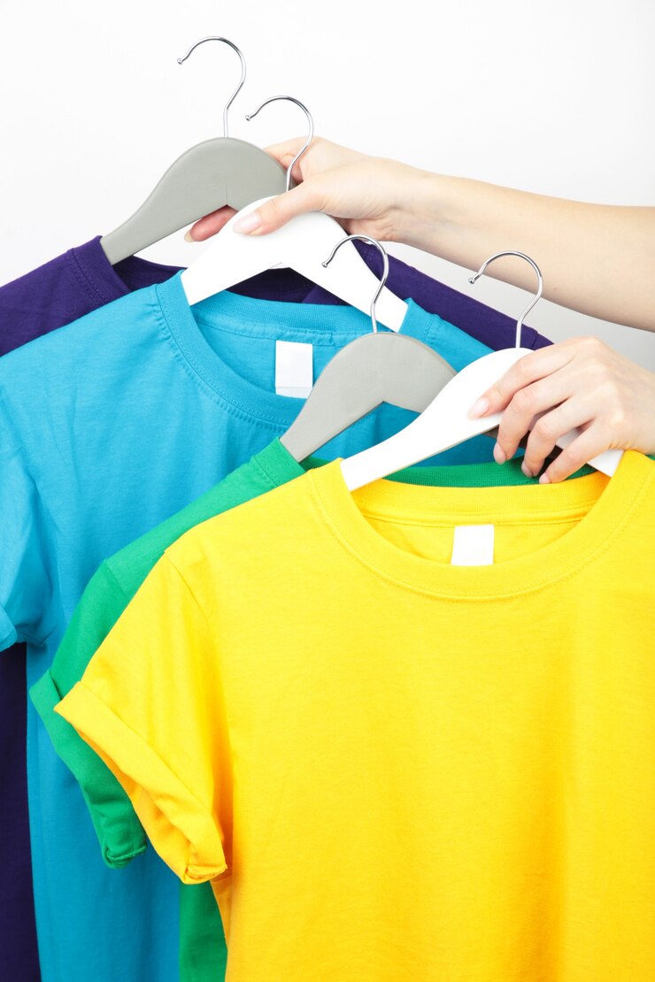 Young girl holding a set of colorful t-shirts