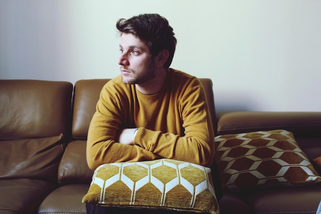 Young man sitting on sofa at home