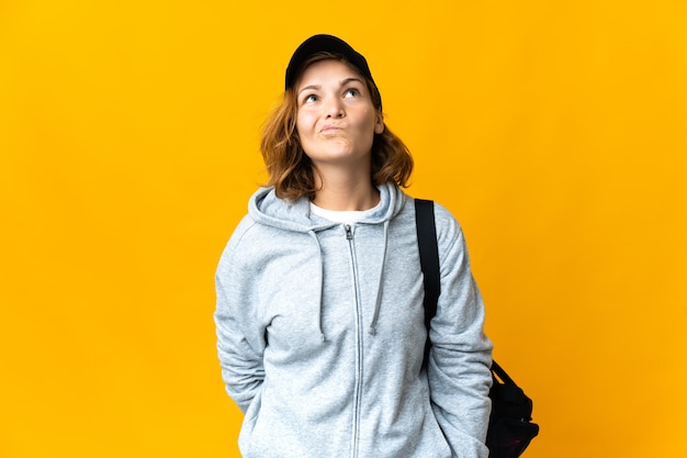 Young sport donna georgiana con borsa sportiva su sfondo isolato e alzando lo sguardo