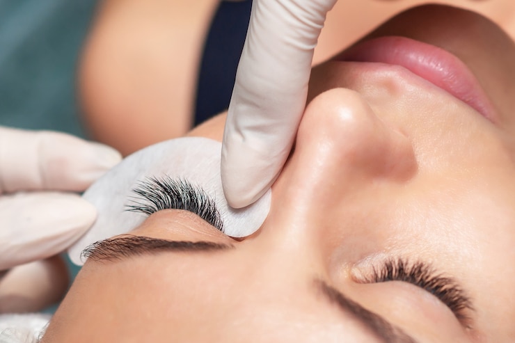 Young woman receiving extending the eyelashes in a beauty salon, close up, eyelash extension procedure