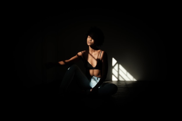 Young woman with eyes closed sitting in dark room