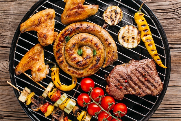 Yummy salsicce a spirale alla griglia e carne con verdure sulla griglia del barbecue