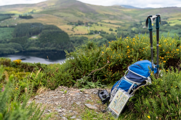 Zaino, binocolo, mappa e bastoni sulla montagna, stile di vita di montagna in Irlanda.