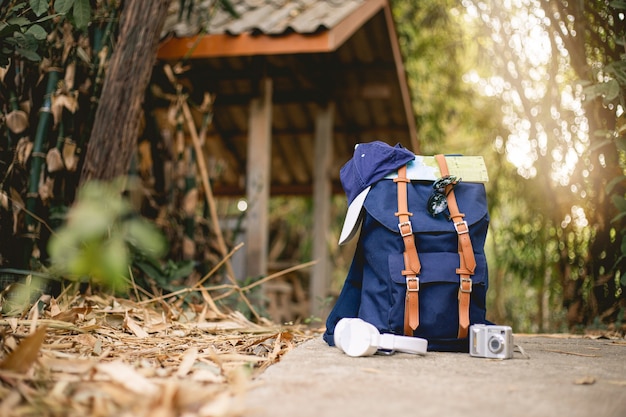 Zaino da viaggio con cappello fotocamera mappa auricolare e smartphone sul Parco