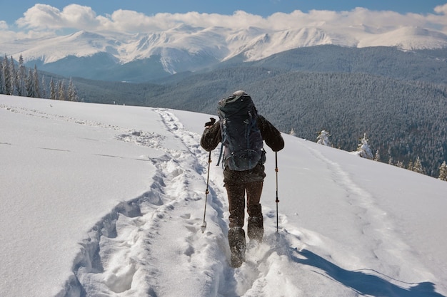 Zaino in spalla dell'uomo che fa un'escursione in montagna innevata in una fredda giornata invernale.