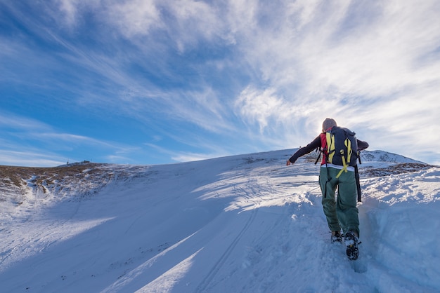 Zaino in spalla donna trekking sulla neve sulle Alpi.