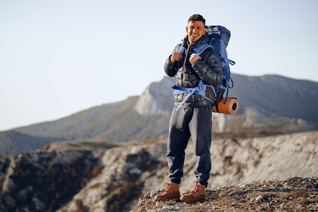 Zaino in spalla maschio in attrezzatura escursionistica in piedi in cima alla montagna