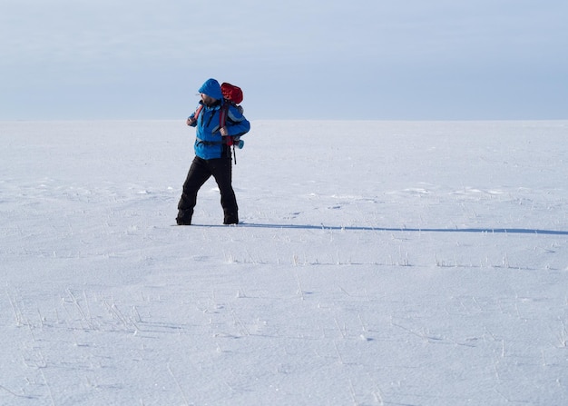 Zaino in spalla solitario che cammina nel deserto della neve