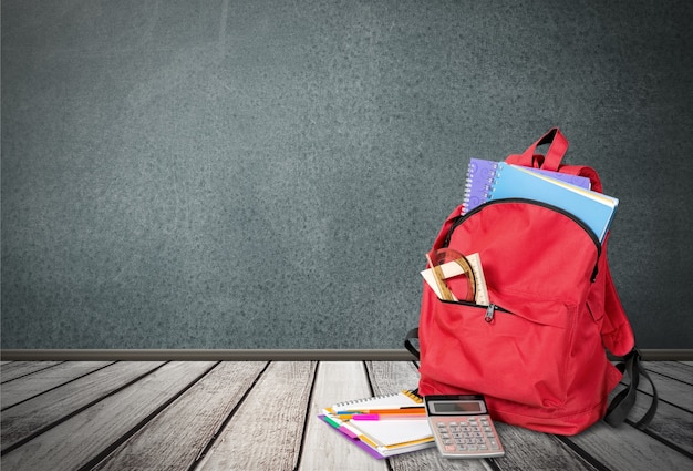 Zaino scuola rosso su sfondo.