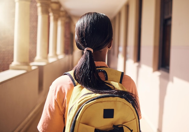 Zaino universitario e istruzione con una donna di colore nel corridoio della scuola per l'apprendimento della borsa di studio e del futuro Obiettivo e conoscenza della visione con uno studente universitario nel campus per la classe di studio e accademico