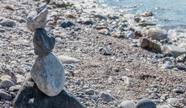 Zen equilibrio pietre ciottoli piramide accatastati sulla spiaggia