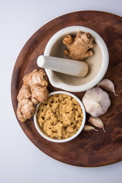 Zenzero fresco e pasta di aglio o purea di Adrak Lahsun in una ciotola di ceramica. Messa a fuoco selettiva