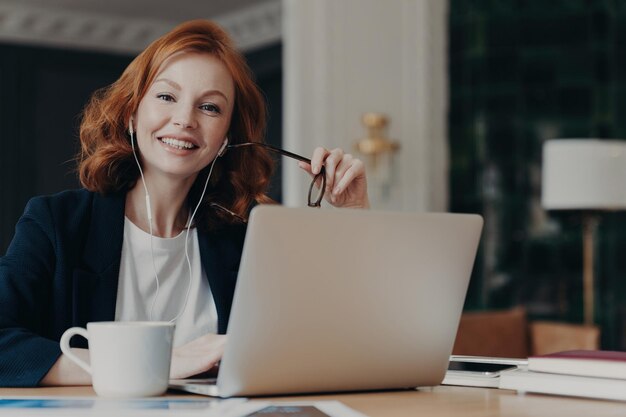 Zenzero libero professionista lavoro a distanza idee per laptop videochiamate auricolari bevanda calda posa felice