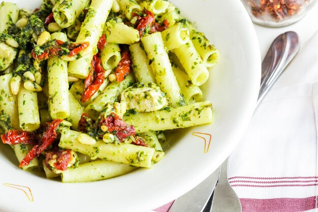 Ziti al pesto con pollo nel piatto in un ristorante italiano.