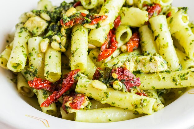 Ziti al pesto con pollo nel piatto in un ristorante italiano.