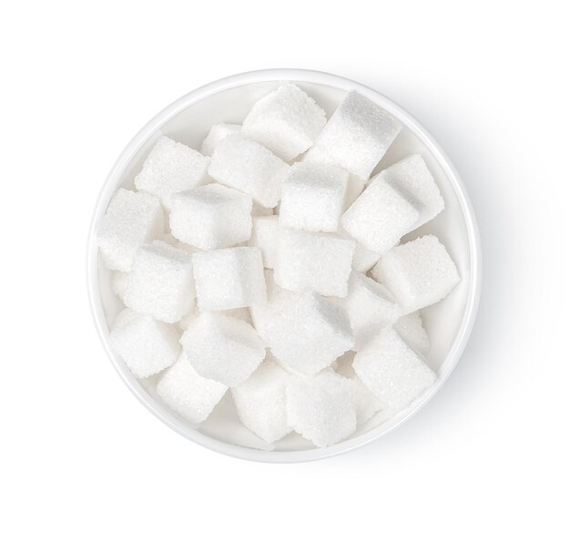 Zollette di zucchero in una ciotola isolata su sfondo bianco, vista dall'alto