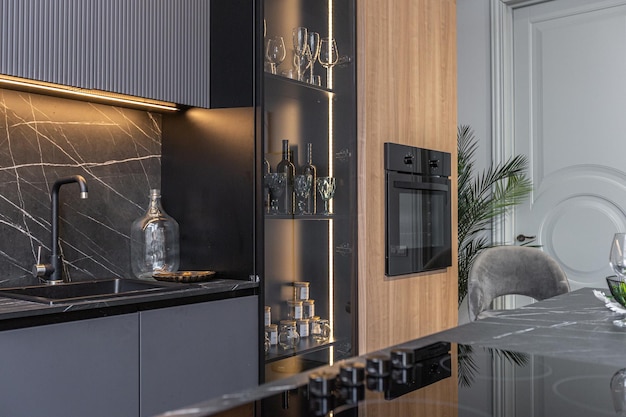 zona cucina scura decorata in legno con isola di coocking in un enorme appartamento moderno spazioso con soffitti in stile loft alti decorazione in legno e pareti grigie