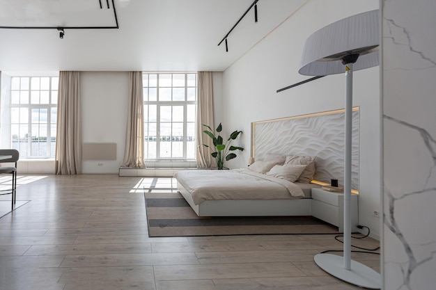 Zona notte in un design di lusso moderno e minimalista di una casa costosa in una giornata di sole pannello decorativo nelle pareti bianche della testiera con illuminazione decorativa in parquet in gesso e nessuno