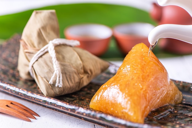 Zongzi gnocco di riso alcalino dolce tradizionale cinese cibo di cristallo su un piatto da mangiare per Dragon Boat Duanwu Festival celebrazione concetto primo piano