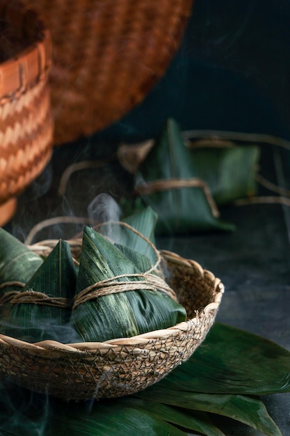 Zongzi Gnocco di riso шт un piroscafo per il tradizionale cinese Dragon Boat Festival Duanwu Festival su sfondo nero scuro