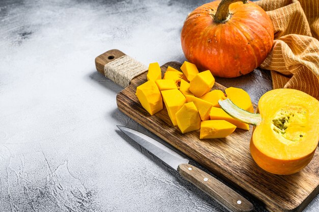 Zucca arancione cruda affettata su un tagliere. Vista dall'alto.