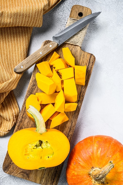 Zucca arancione cruda affettata su un tagliere. Vista dall'alto.