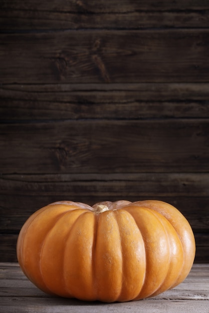 Zucca arancione sulla vecchia tavola di legno