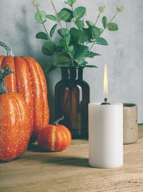 Zucca artificiale con candela accesa su tavolo di legno Moody Style Halloween concept Copia spazio