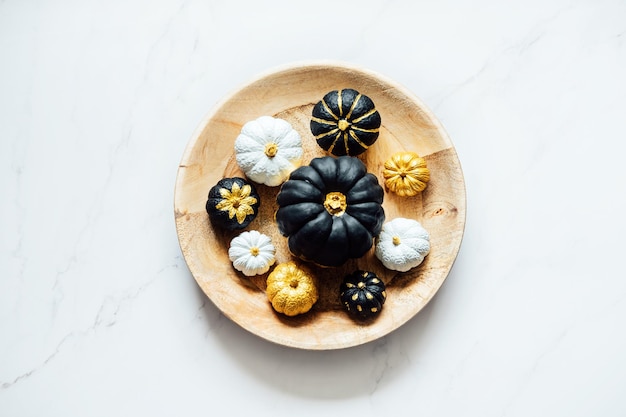 Zucca bianca oro nero per halloween e ringraziamento vista dall'alto minima composizione autunnale piatta