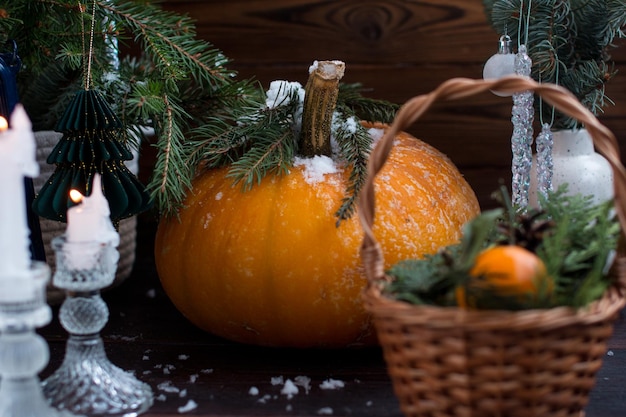 zucca congelata sotto l'albero fette di arance secche e mandarini in un cesto biglietto di Natale