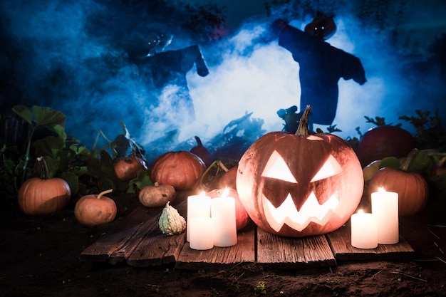 Zucca d'ardore con gli spaventapasseri sul campo per Halloween