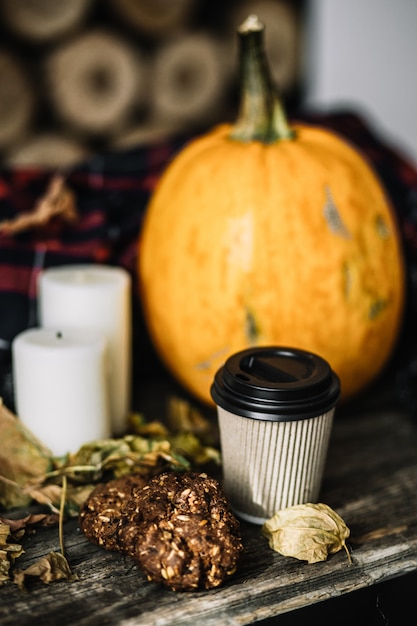 Zucca di Halloween con la tazza di caffè su legno.