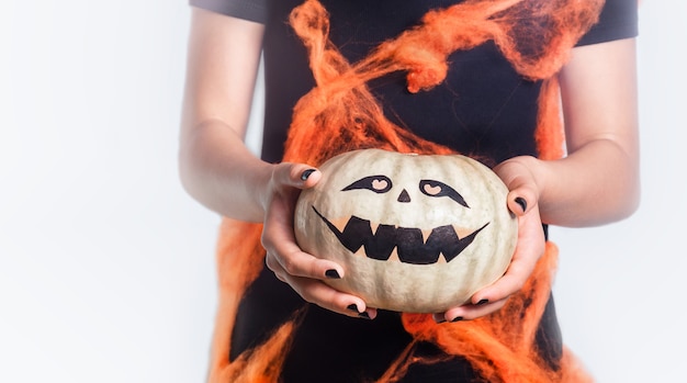 Zucca di Halloween luminosa in mani femminili protese in avanti